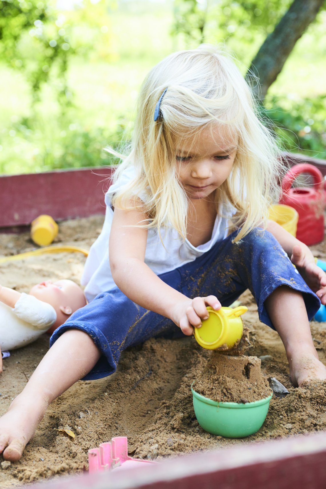 Mína si hraje na svém maličkém pískovišti, ze kterého poctivě sype všechen písek ven.